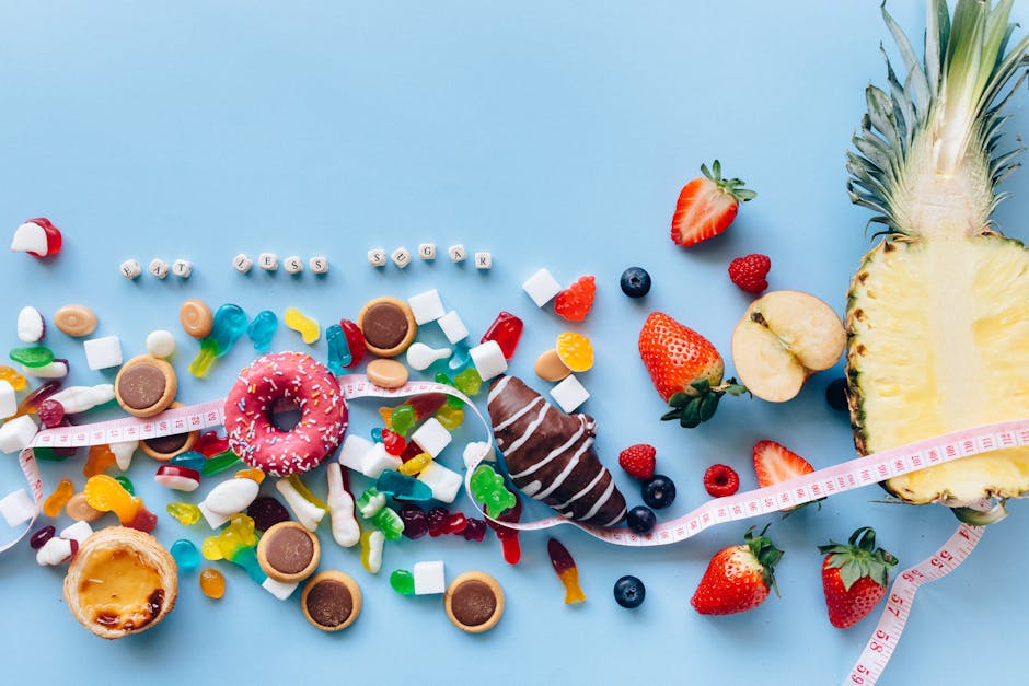 Flat lay of sweets and fruits on blue background with health message 'Eat Less Sugar'.