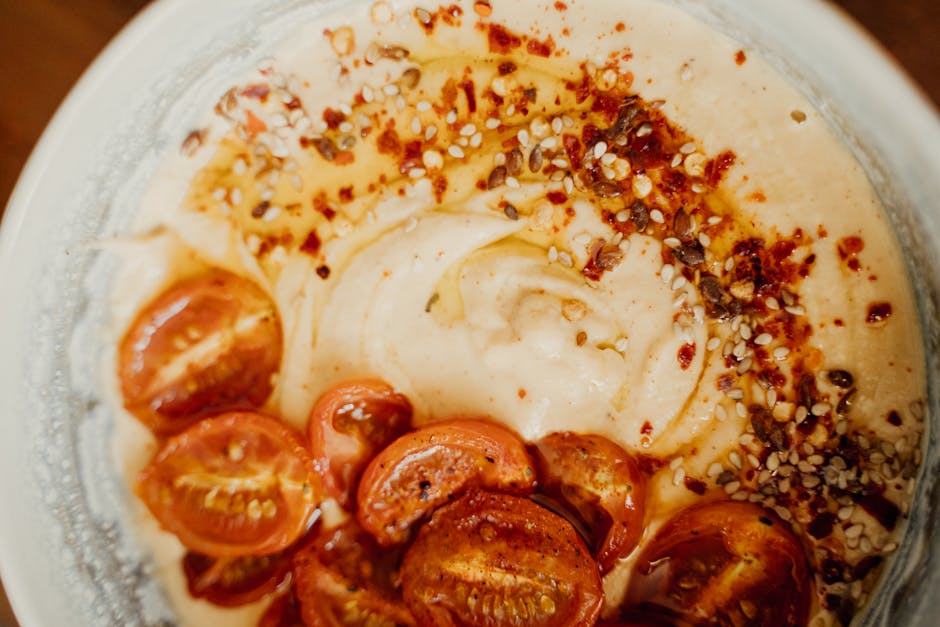 Delicious spiced hummus topped with roasted cherry tomatoes and sesame seeds.