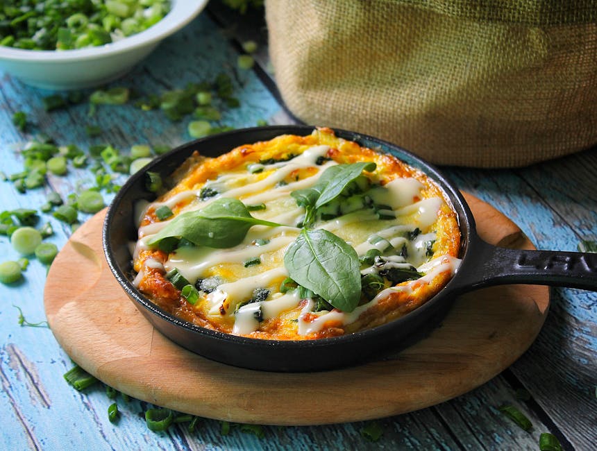 A tempting baked casserole topped with fresh basil leaves in a cast iron skillet, perfect for food photography.